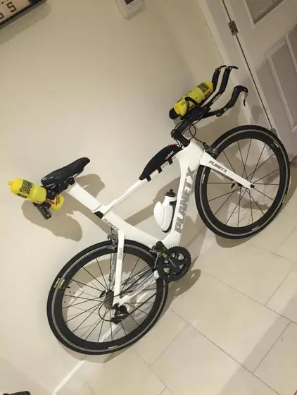 White Giant time trial bike hung on the workshop wall